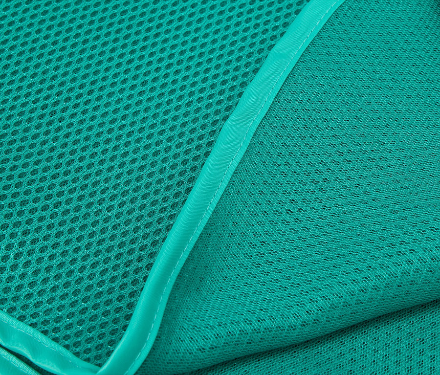 Gros plan sur deux couches de tissu en maille turquoise, l'une à grosses mailles et l'autre à mailles fines.