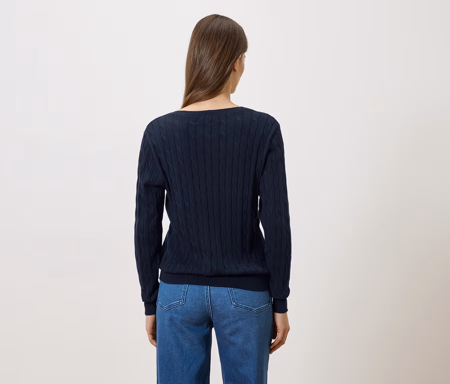 Vue arrière d'une femme aux longs cheveux bruns portant un pull en tricot bleu marine et un jean.