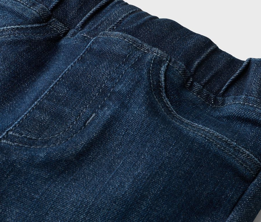 Gros plan sur un jean avec une taille élastique et une poche plaquée.