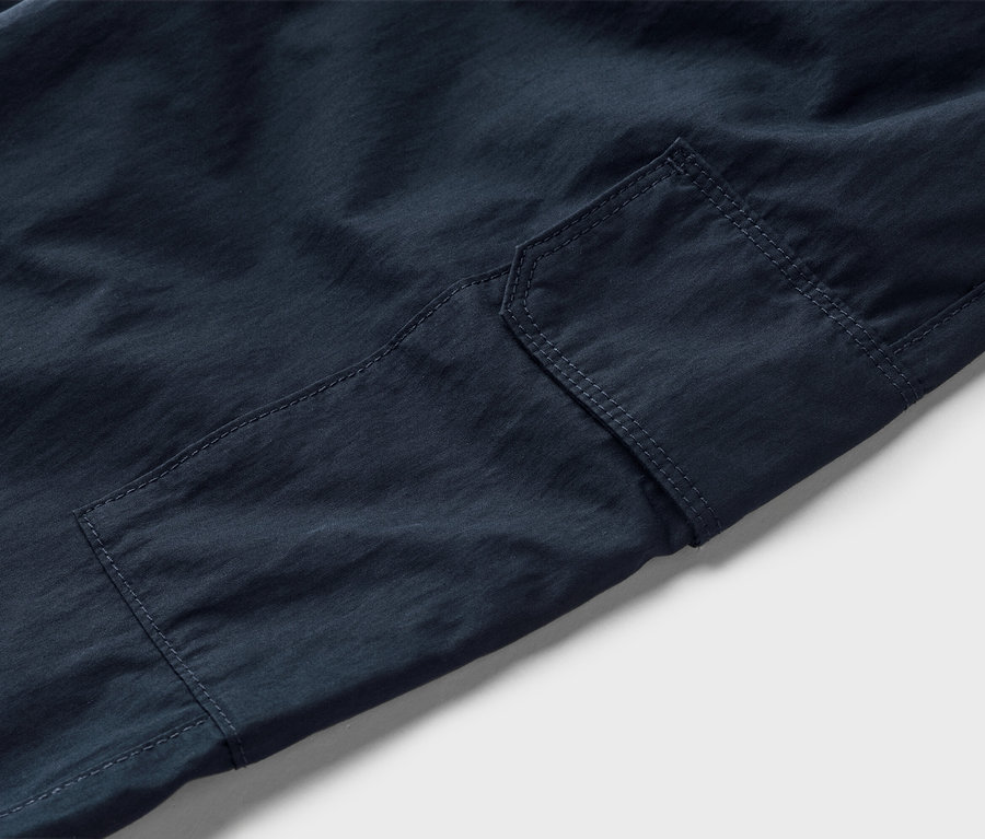 Gros plan d'un pantalon cargo bleu marine avec une poche plaquée.