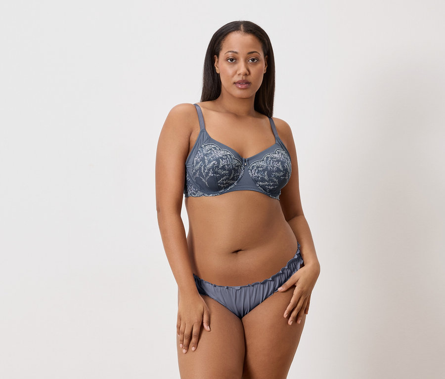 Femme portant un soutien-gorge et une culotte gris à motif floral.