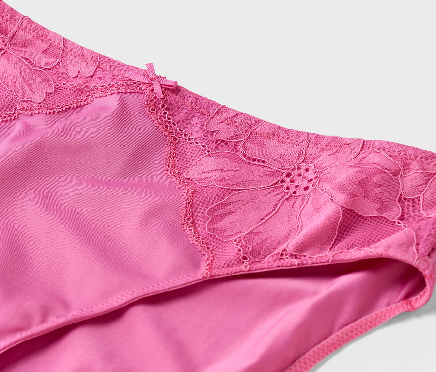 Gros plan d'une culotte rose avec de la dentelle florale à la taille.