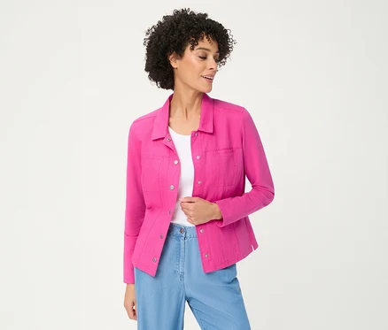 Femme aux cheveux bouclés portant une veste en jersey Olsen rose ouverte sur un haut blanc et un pantalon bleu clair, regardant sur le côté.
