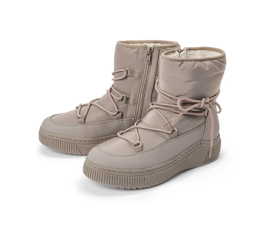 Deux bottes d'hiver marron clair avec des semelles épaisses et crantées, des tiges rembourrées et des lacets rose clair. La botte gauche a une fermeture éclair latérale, et les deux sont doublées de fausse fourrure blanche.