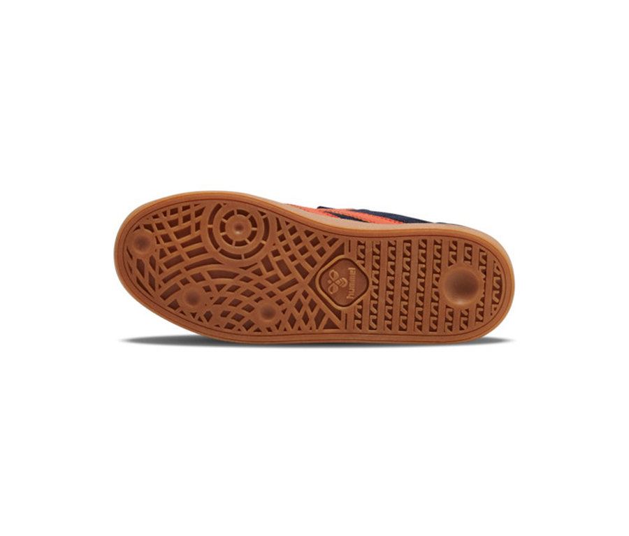 Vue de dessous de la semelle d'une basket hummel® « VM78 CPH JR » en gomme marron, avec motif adhérent texturé et logo hummel. La tige multicolore est visible.