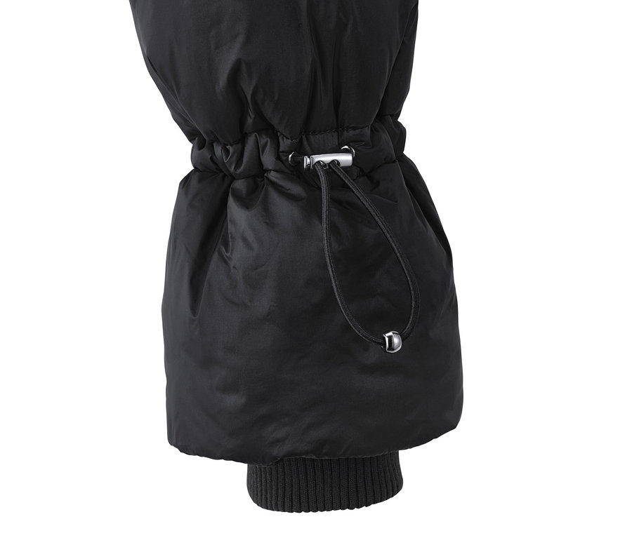 Gros plan sur la manche d'un manteau matelassé noir avec cordon de serrage.