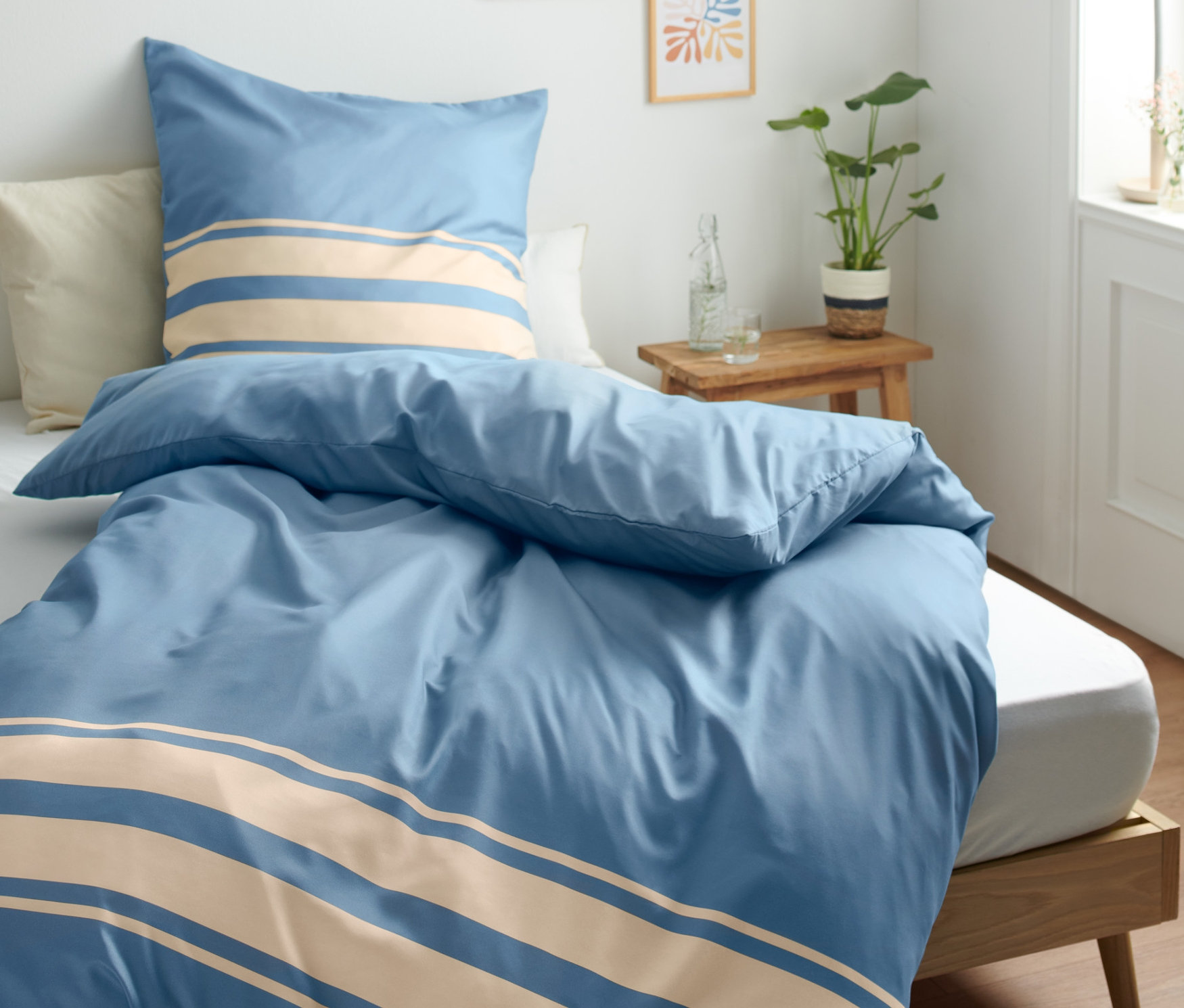 Parure de lit en microfibre bleue rayée, taille normale sur un lit.