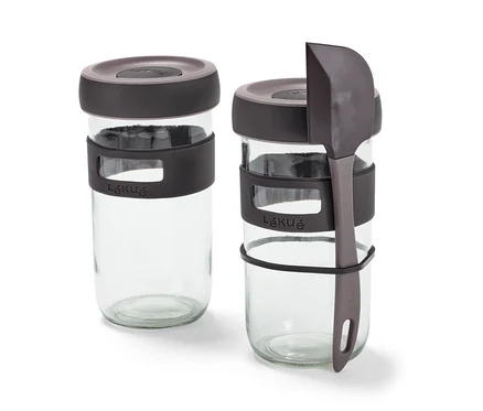 Deux bocaux du kit de démarrage pour levain et une spatule grise.
