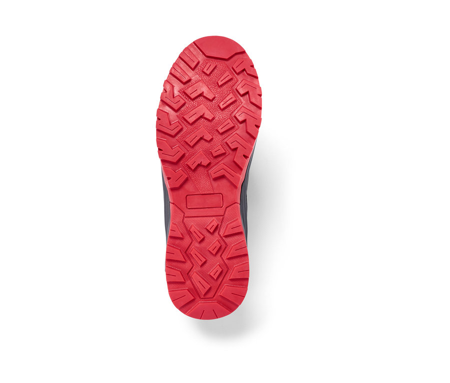 Gros plan sur la semelle rouge d'une chaussure de trekking.