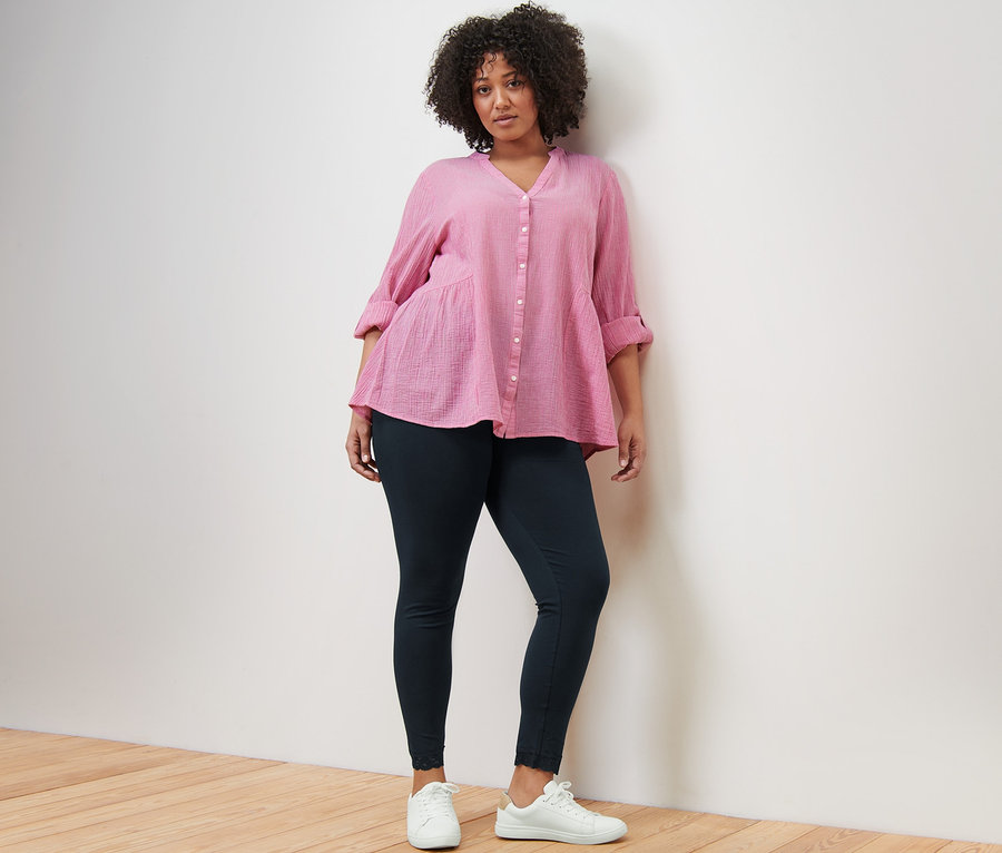 Femme posant en tunique longue rayée et legging avec bord en dentelle.