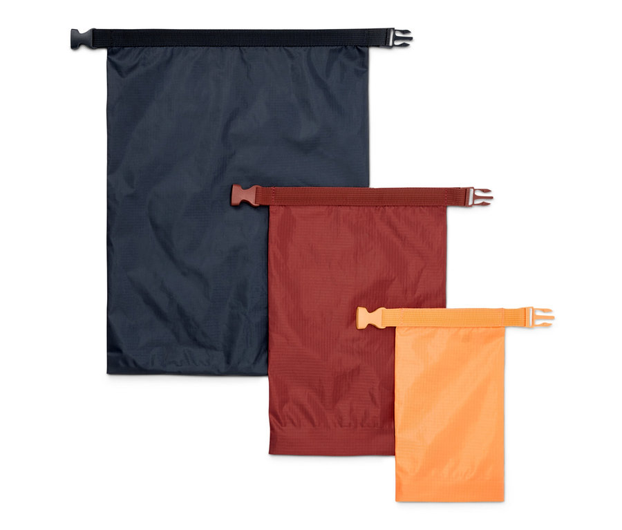 Trois sacs fourre-tout imperméables en bleu, marron et orange.