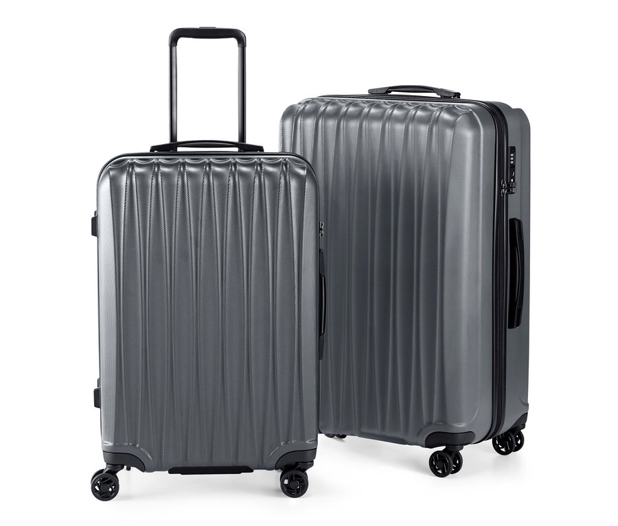 Lot de valises rigides gris, de taille moyenne et grande.
