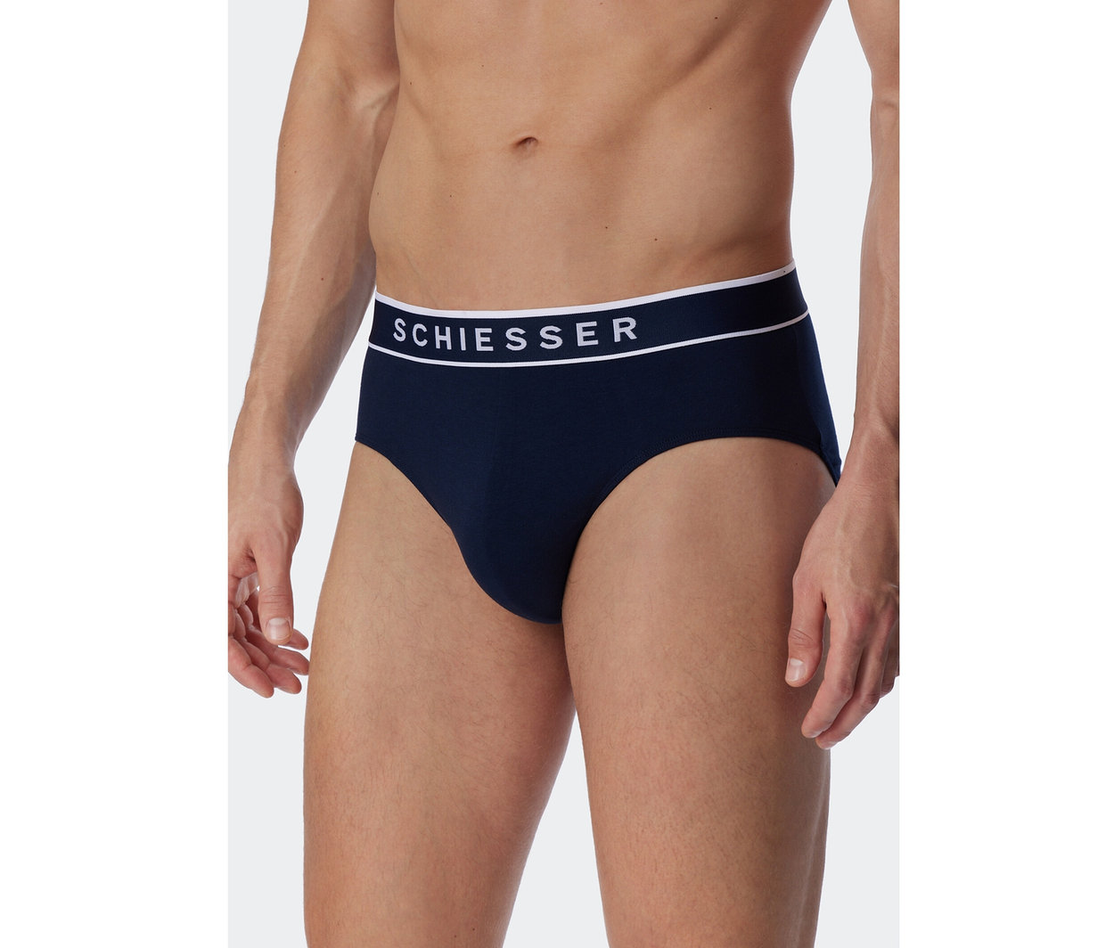 Homme portant un slip SCHIESSER Rio bleu foncé avec une ceinture blanche et le logo SCHIESSER.