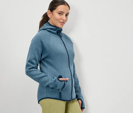 Femme posant en veste en polaire tricotée bleu foncé.