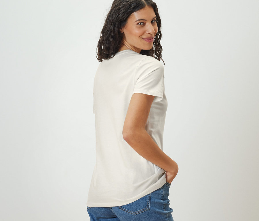 Femme regardant par-dessus son épaule portant un t-shirt basique blanc.