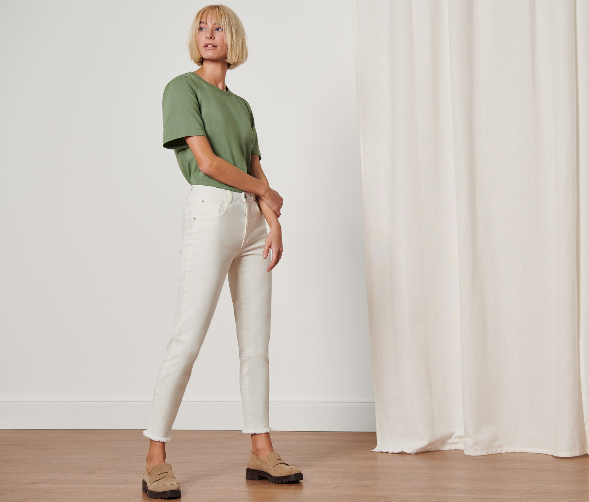 Femme posant en jean moderne « Fit Lilly » et t-shirt vert.