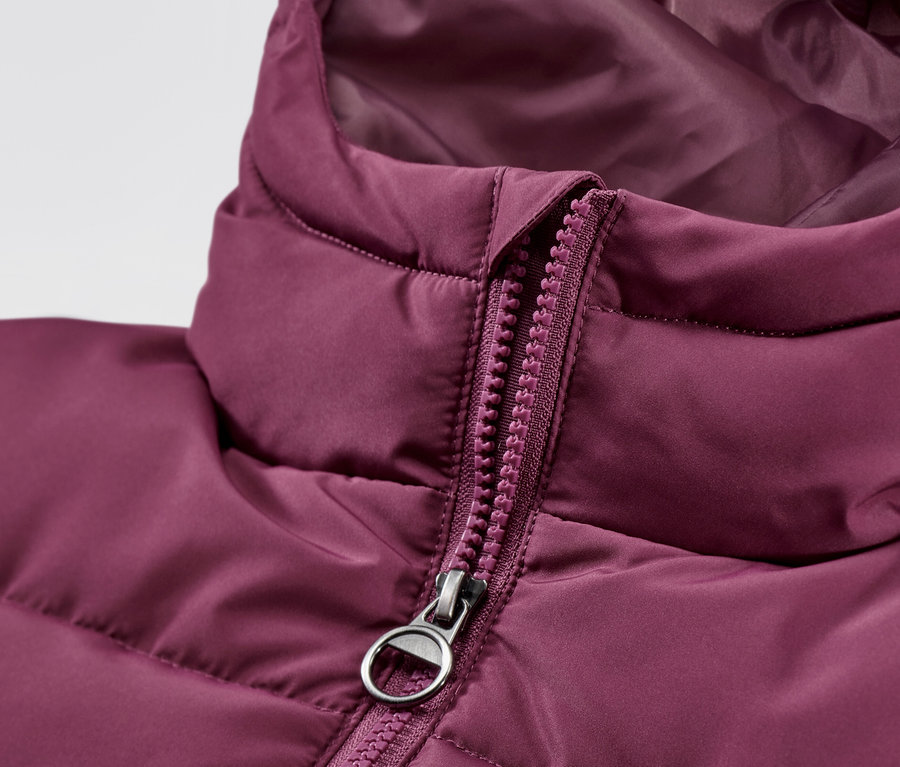 Détail d'un manteau thermique pour enfant rouge et violet.