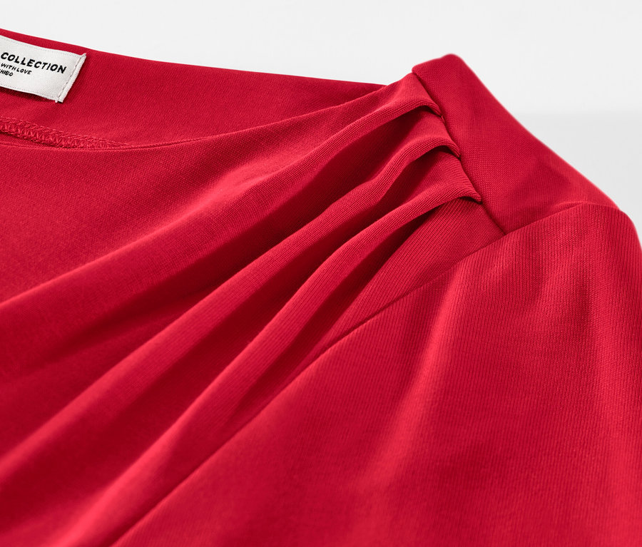 Gros plan d'une blouse rouge avec des fronces.