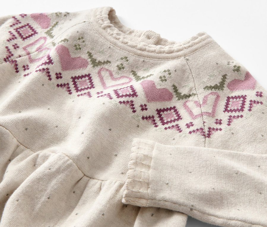 Gros plan sur une robe en maille pour enfant avec motif norvégien.