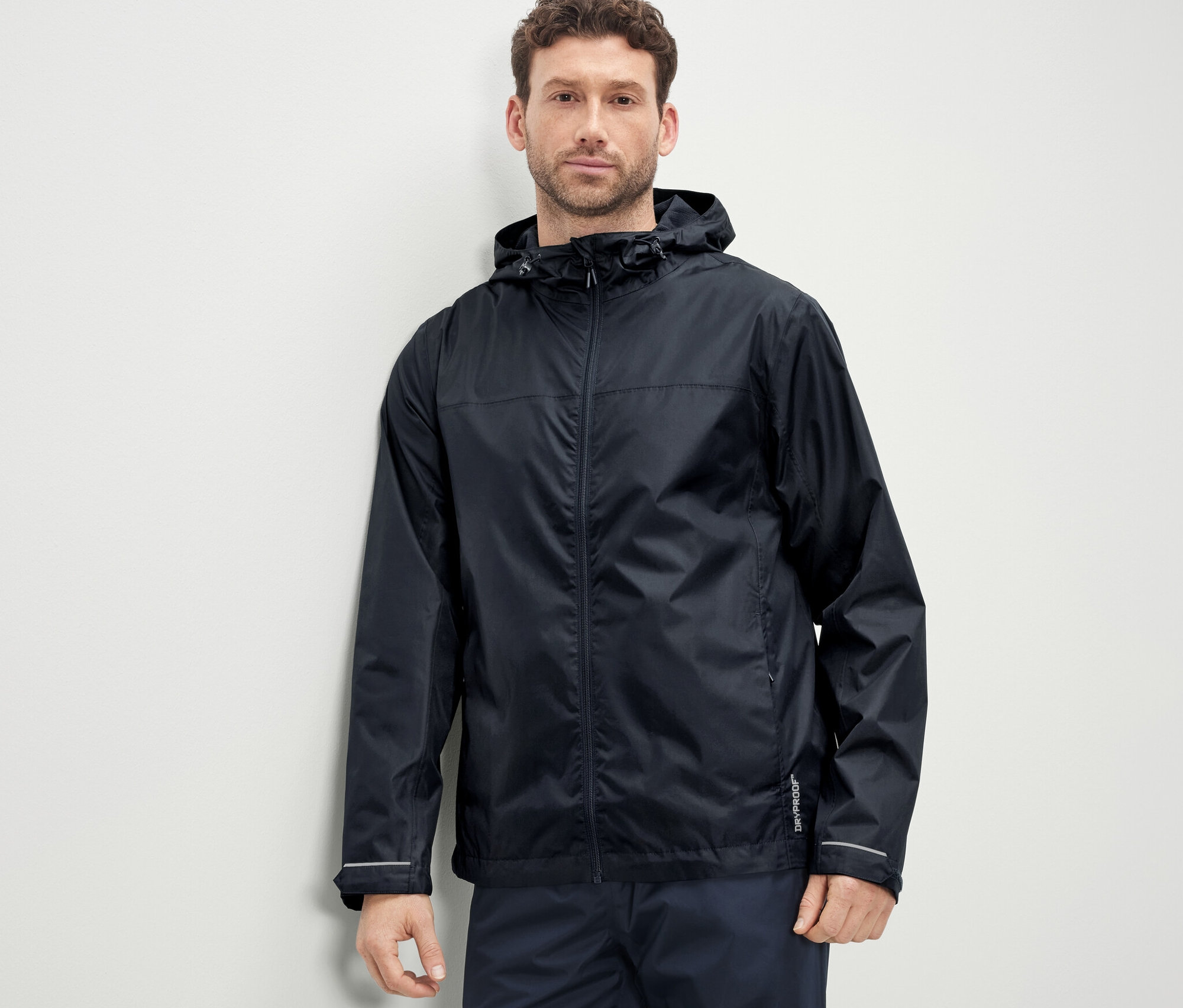 Un homme porte une veste de pluie unisexe.