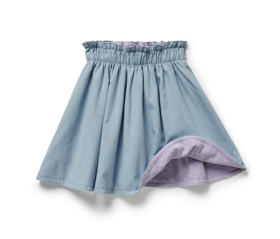 Jupe réversible denim bleue pour enfants avec une doublure violette à pois blancs.