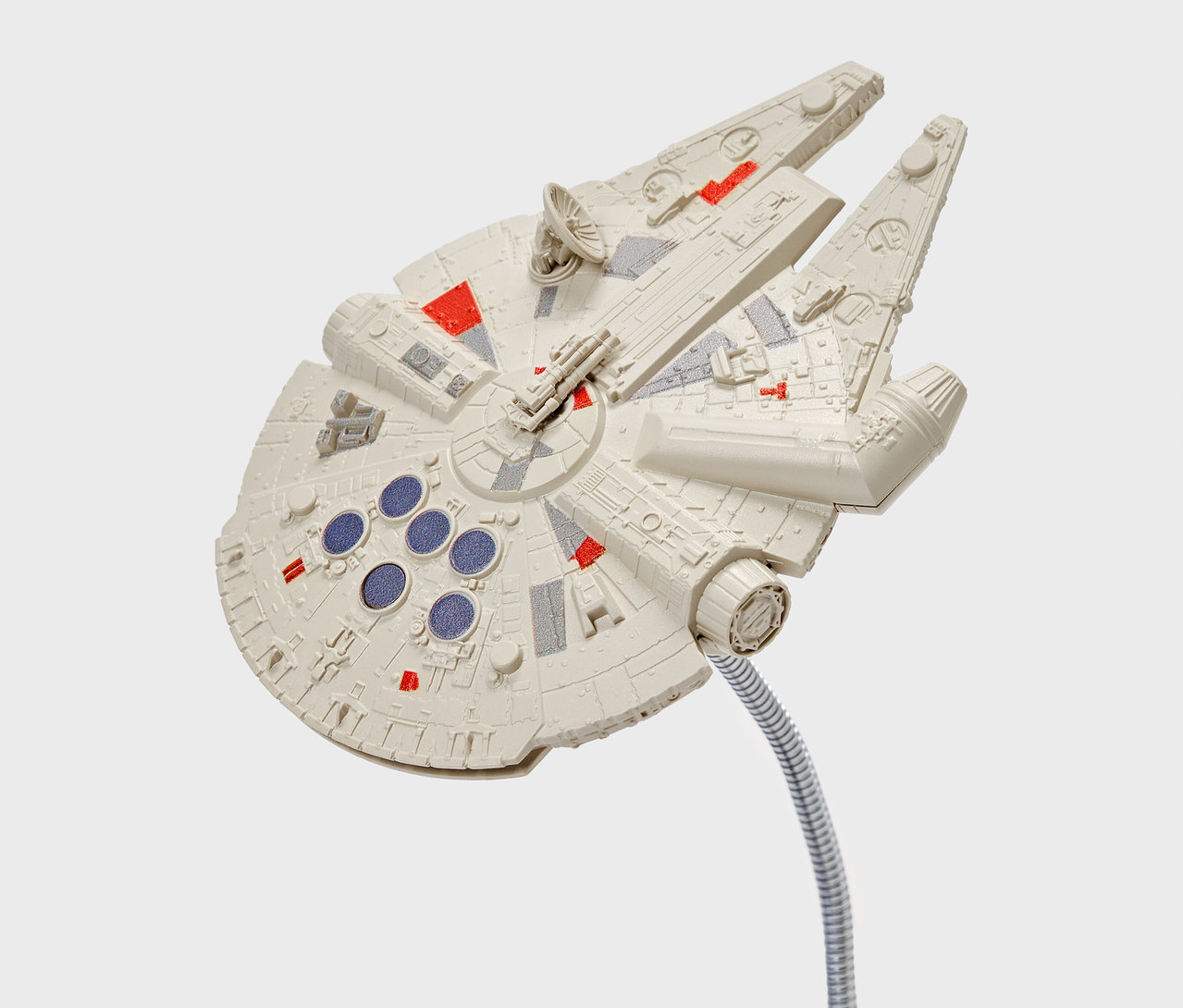 Maquette du Millennium Falcon avec des détails rouges et gris, fixée sur une tige argentée flexible.