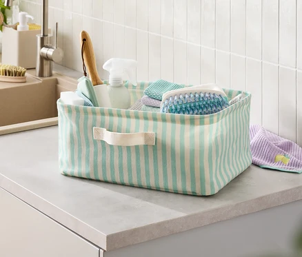 Panier rayé avec des produits de nettoyage sur le comptoir.