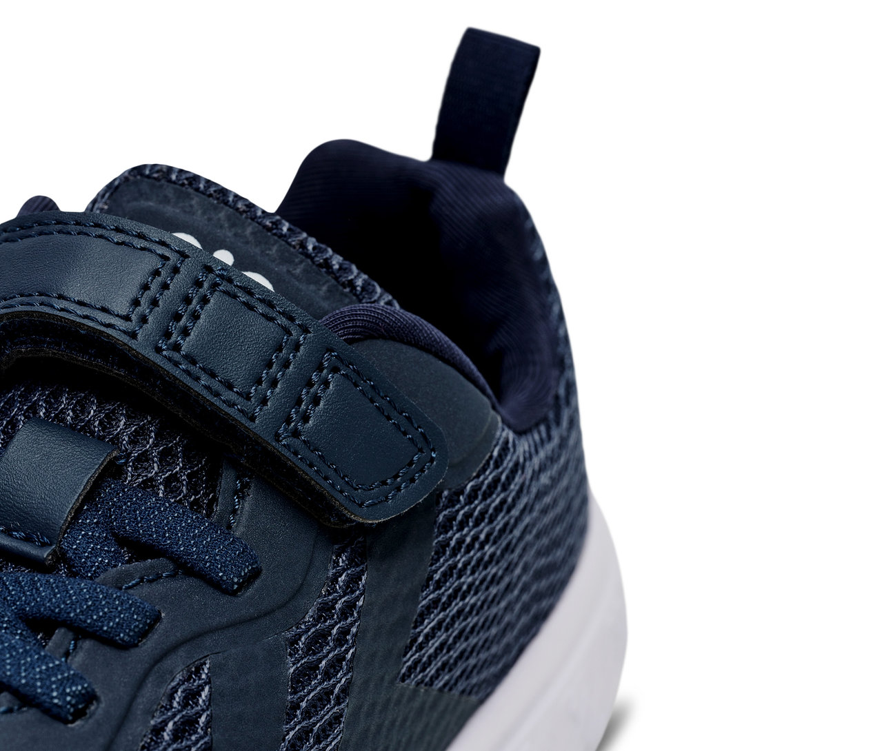 Gros plan d'une chaussure bleu marine Hummel Actus Recycled Jr avec des lacets et une fermeture velcro.