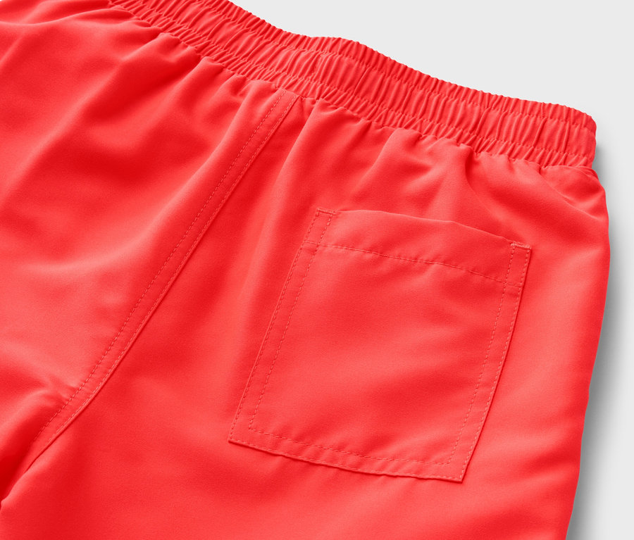 Gros plan sur un boardshort rouge pour enfant avec une taille élastique et une poche arrière.