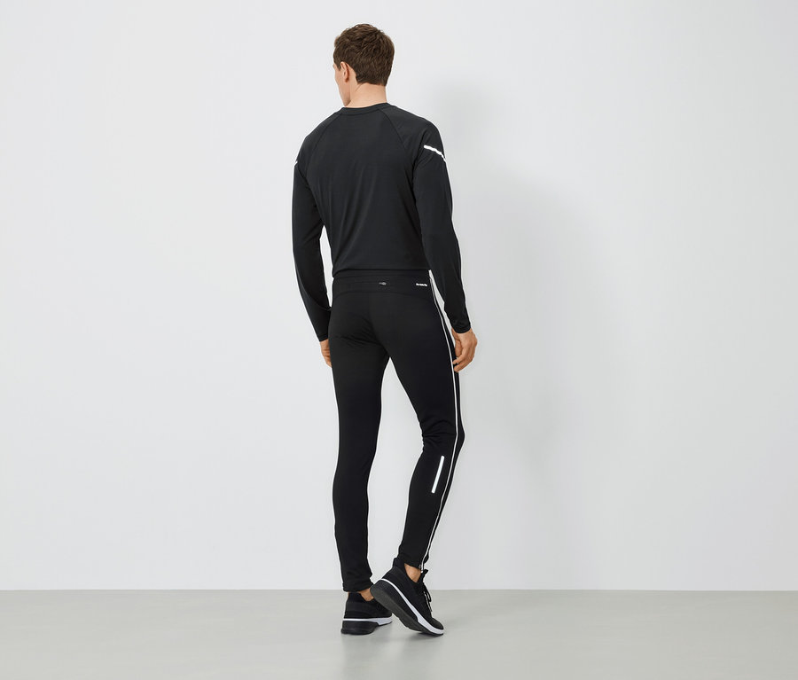 Un homme vu de dos porte des vêtements de sport noirs.