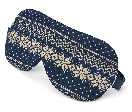 Masque de sommeil bleu avec motif de flocons de neige sur fond blanc.