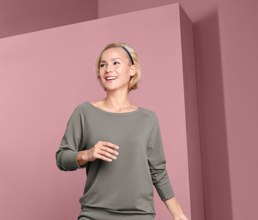 Femme en pose d'arbre portant un sweat-shirt de yoga.