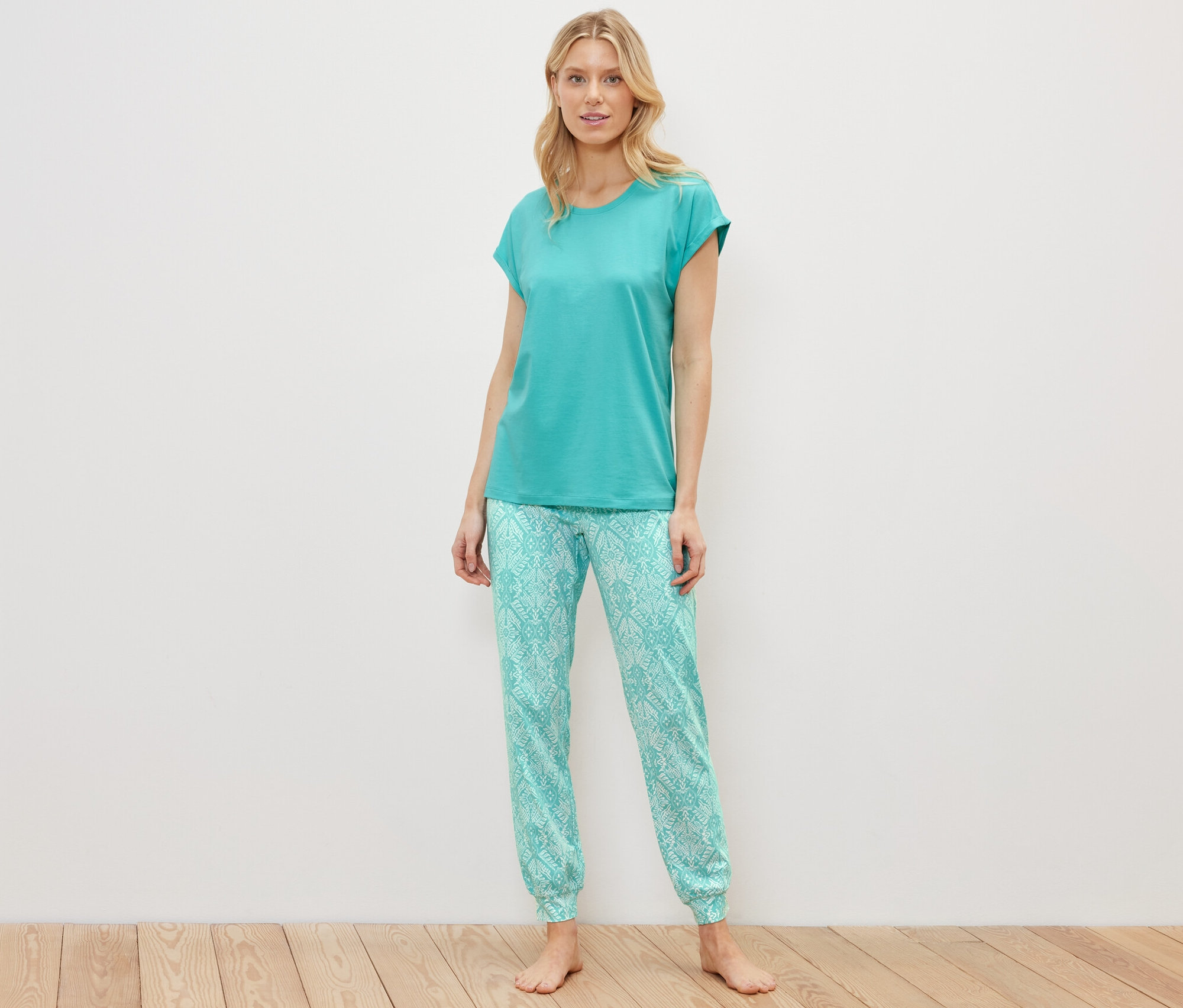 Femme blonde debout portant un ensemble pyjama.