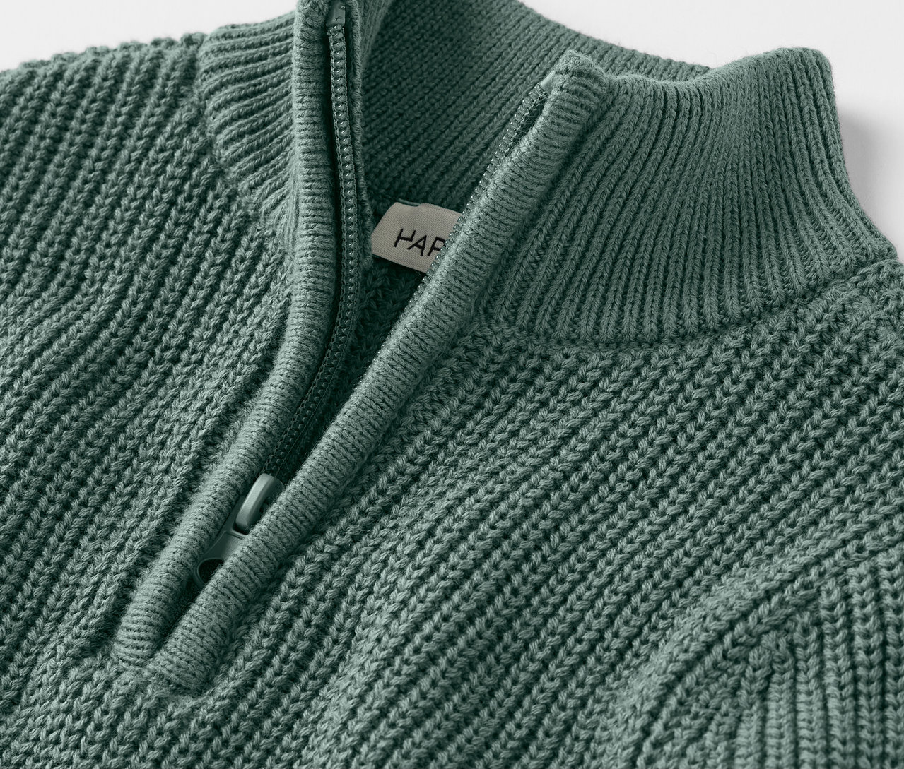 Gros plan d'un pull camionneur en tricot pour enfants avec une courte fermeture éclair.