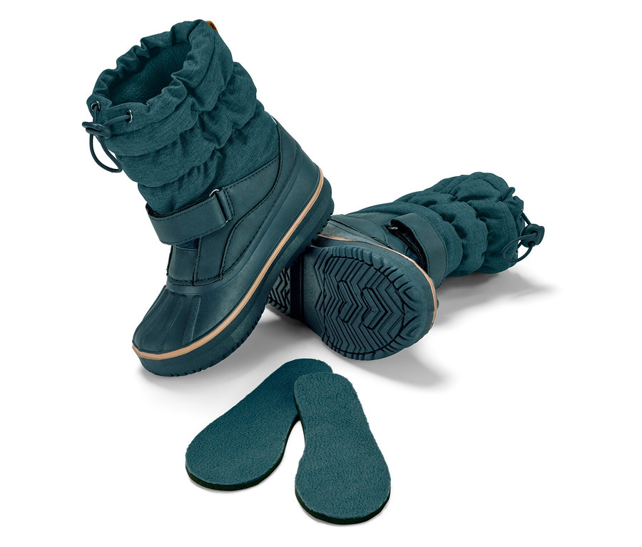 Deux bottes d'hiver et deux semelles sur fond blanc.