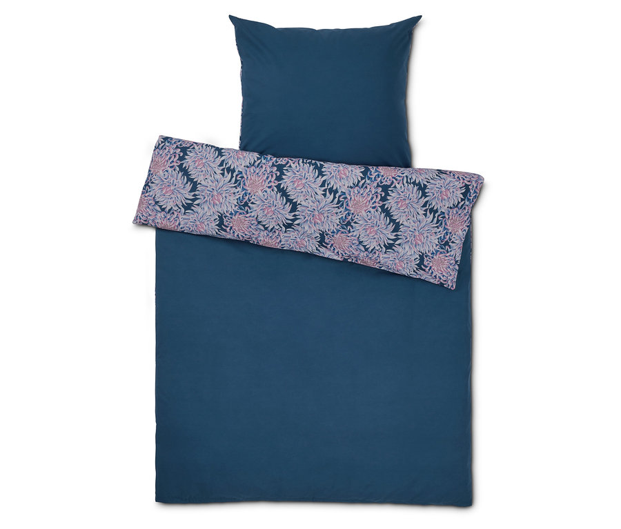 Parure de lit bleue avec motif floral sur la taie d'oreiller.