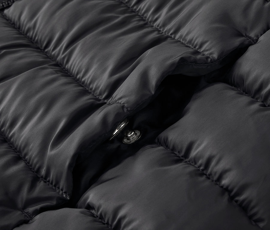 Gros plan d'une veste matelassée noire avec un bouton-pression.