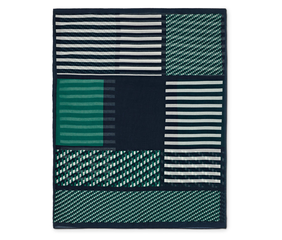 Couverture décorative avec un motif géométrique dans les tons de vert et de bleu.
