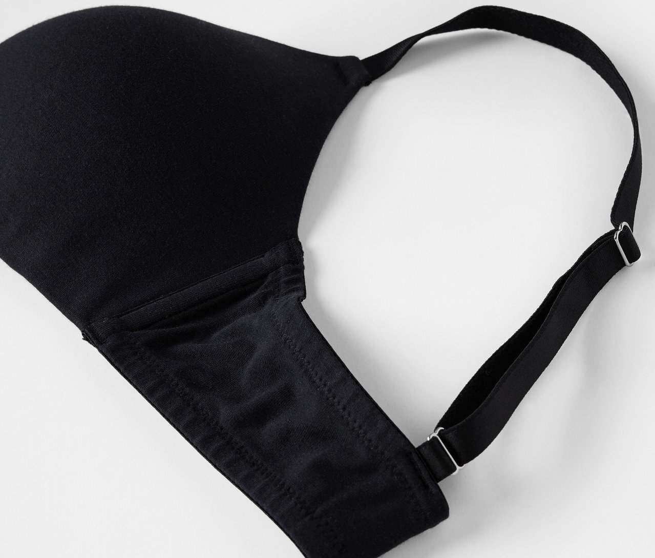 Détail d'un soutien-gorge noir sur fond blanc.