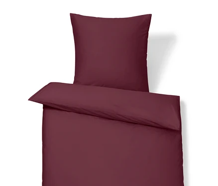 Linge de lit bordeaux avec oreiller et couette.