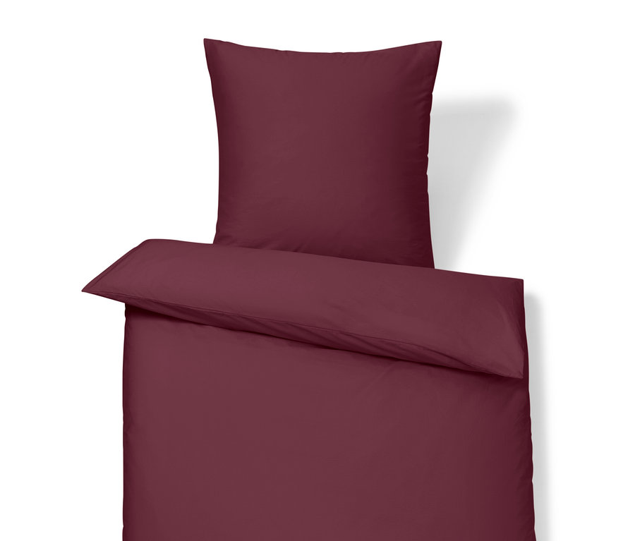 Linge de lit bordeaux avec oreiller et couette.