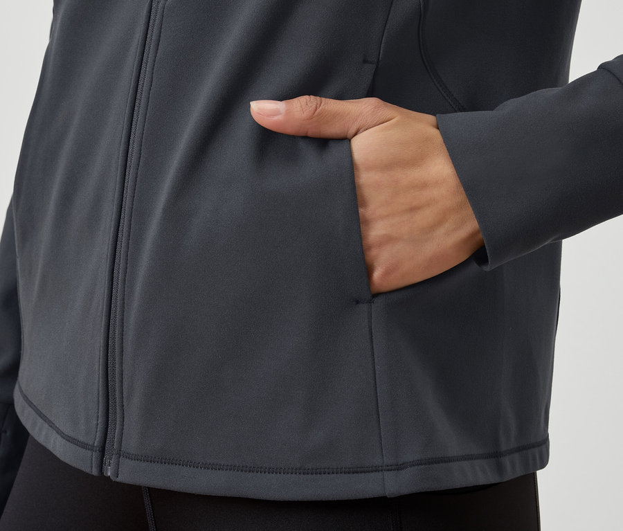 Gros plan sur un sweat-shirt gris zippé avec une main dans la poche.