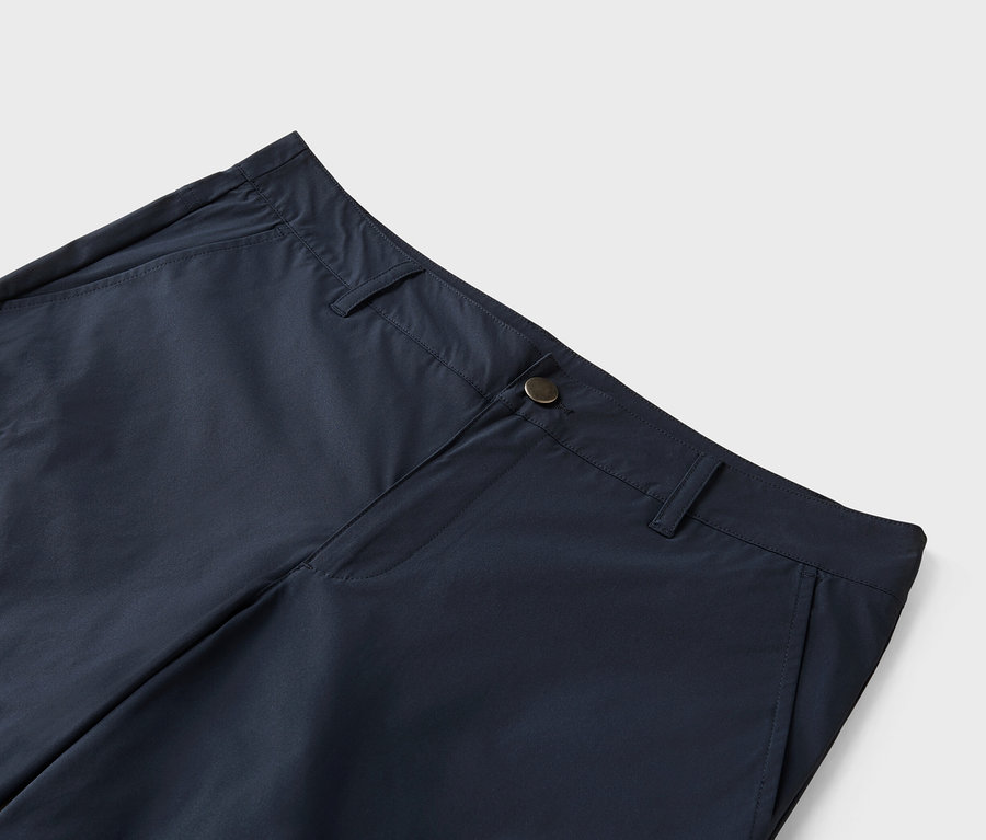 Gros plan d'un pantalon bleu marine avec fermeture à bouton.