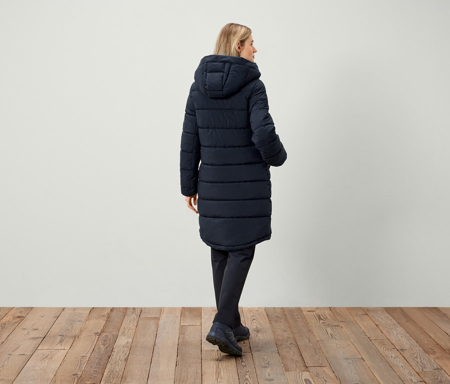 Femme portant une doudoune bleu marine à capuche, vue de dos.
