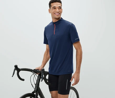 Un homme à côté d'un vélo porte un maillot de cyclisme.