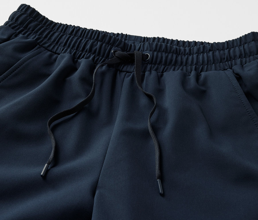 Détail d'un pantalon de jogging en softshell avec cordon de serrage noir à la taille.