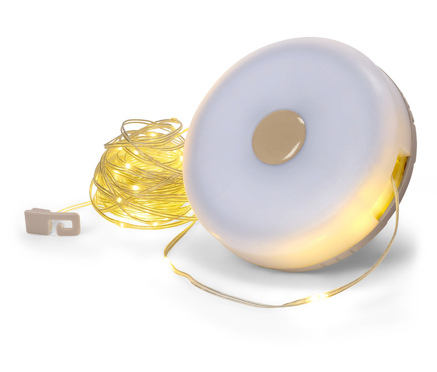 Guirlande lumineuse enroulée dans une boîte de rangement ronde blanche.