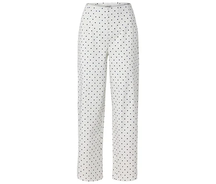 Un pantalon long blanc avec des pois noirs.