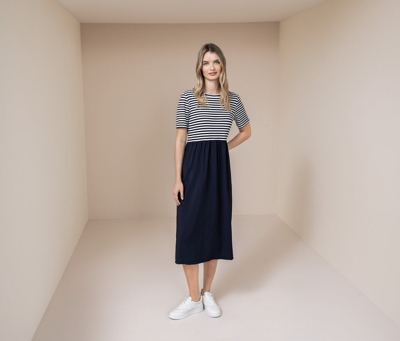 Femme portant une robe Street One avec un haut rayé bleu et blanc et une jupe bleue, ainsi que des baskets blanches.