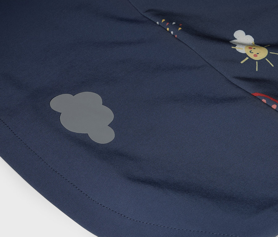 Gros plan d'un tissu bleu marine avec un patch nuage gris et un imprimé visage de soleil.